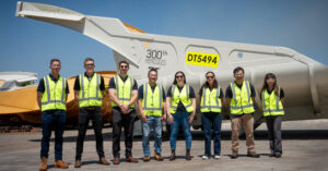 The Fortescue and Schlam equipos in high vis, posing in front of Fortescue's 300th Hercules Caja de Camión at Schlam's Forrestfield facility.