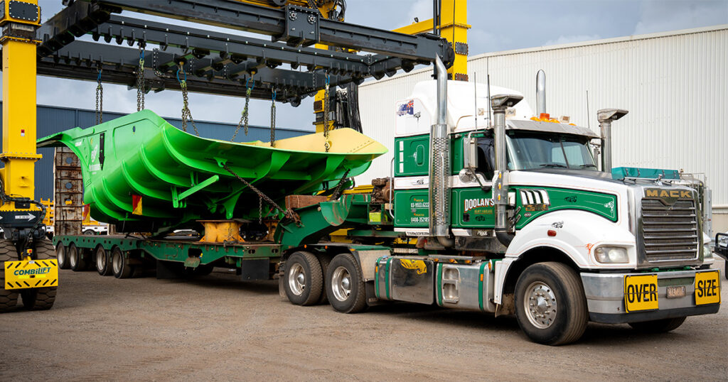 Performance Minaría's distinctive green Hercules caja de camión siendo cargados por CombiLift onto truck leaving Schlam's Forrestfield facility